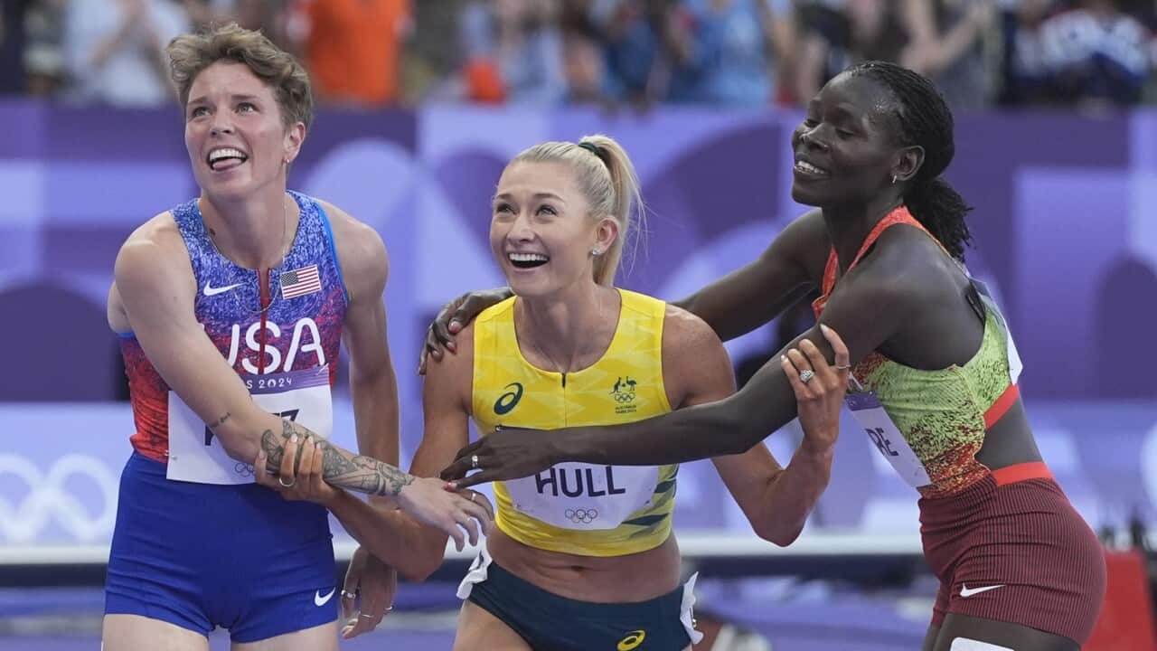 Jessica Hull being congratulated by Susan Lokayo Ejore of Kenya, and Nikki Hiltz, of the United States