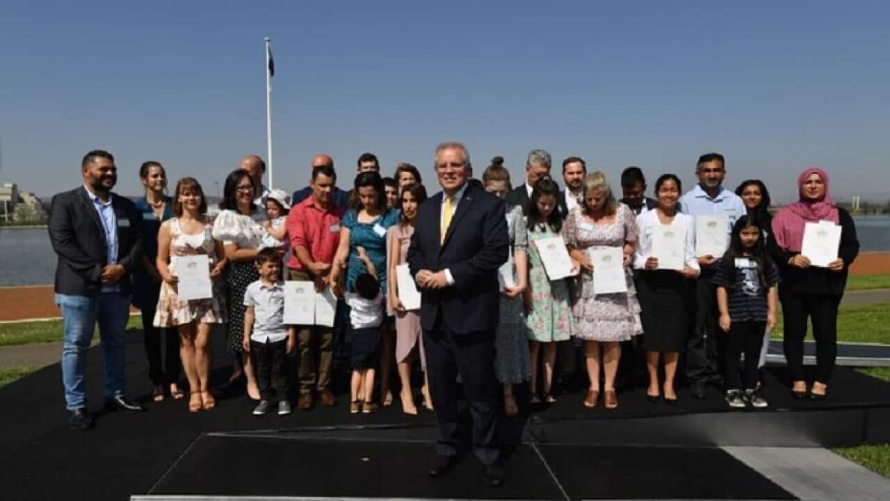 Prime Minister Scott Morrison poses for photos with new citizens during an Australia Day Citizenship Ceremony in Canberra.