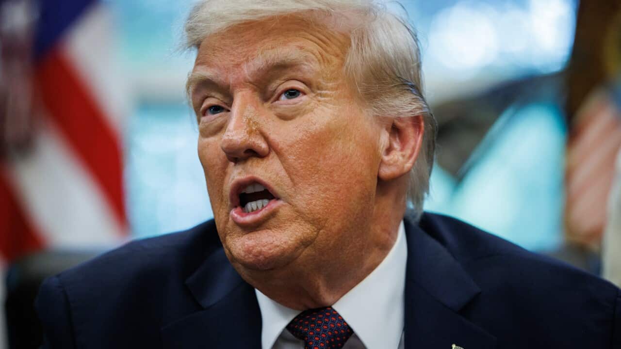 Donald Trump wearing a dark blue jacket with an American flag pin on it.