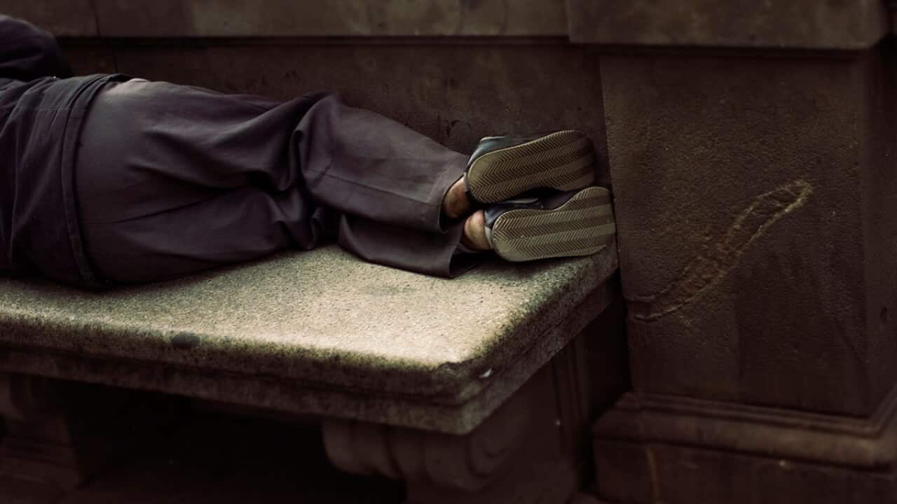 Homeless person sleeping on a bench