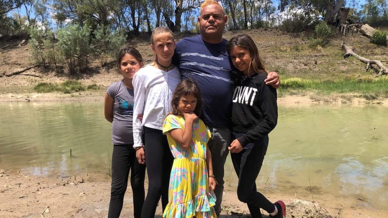 Owen Whyman and his family standing by the Darling River which flows through their town of Wilcannia/