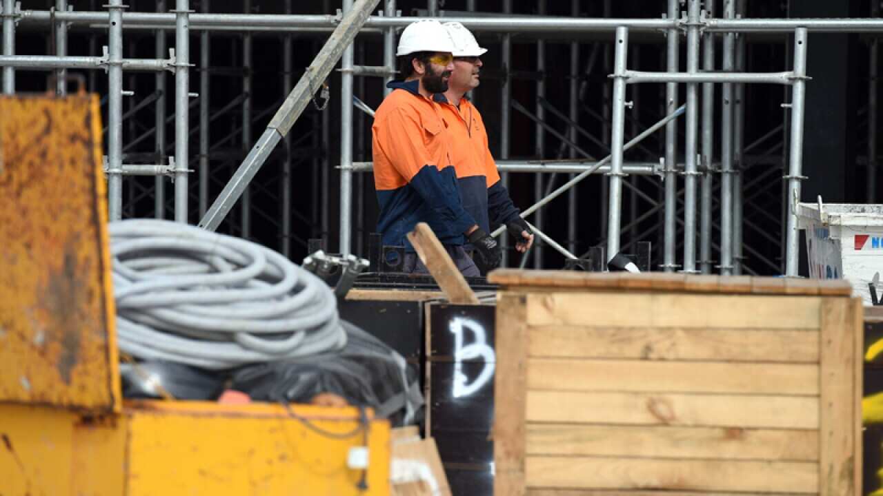 Construction workers walk through a work site