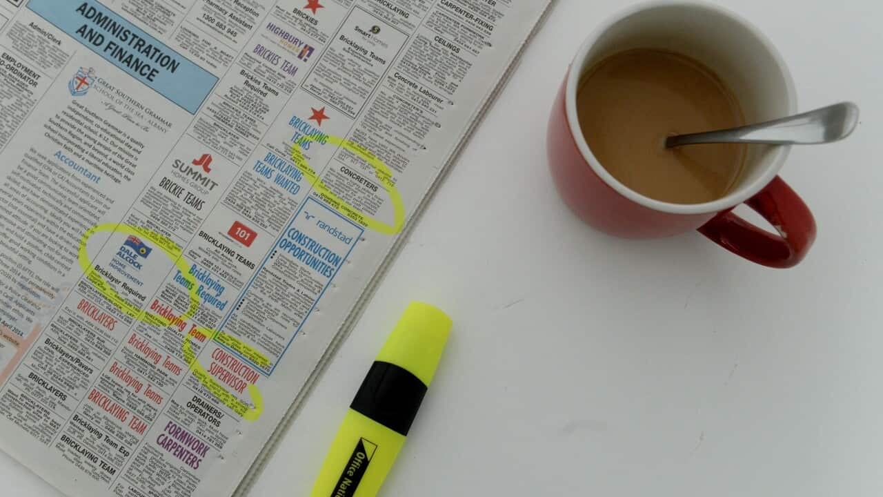 Employment advertising and a cup of coffee are seen in a newspaper.