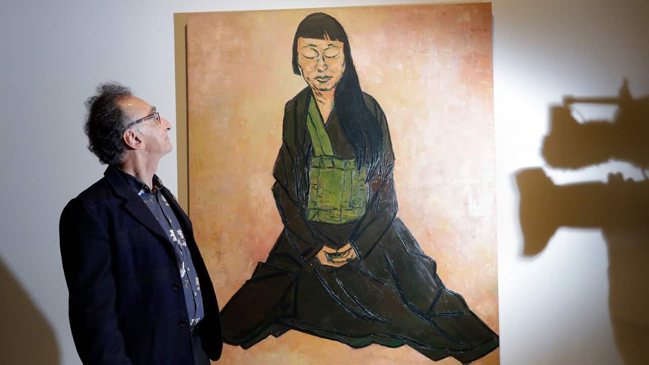 Artist Tony Costa poses with his portrait of artist Lindy Lee after he won the Archibald Prize in Sydney.