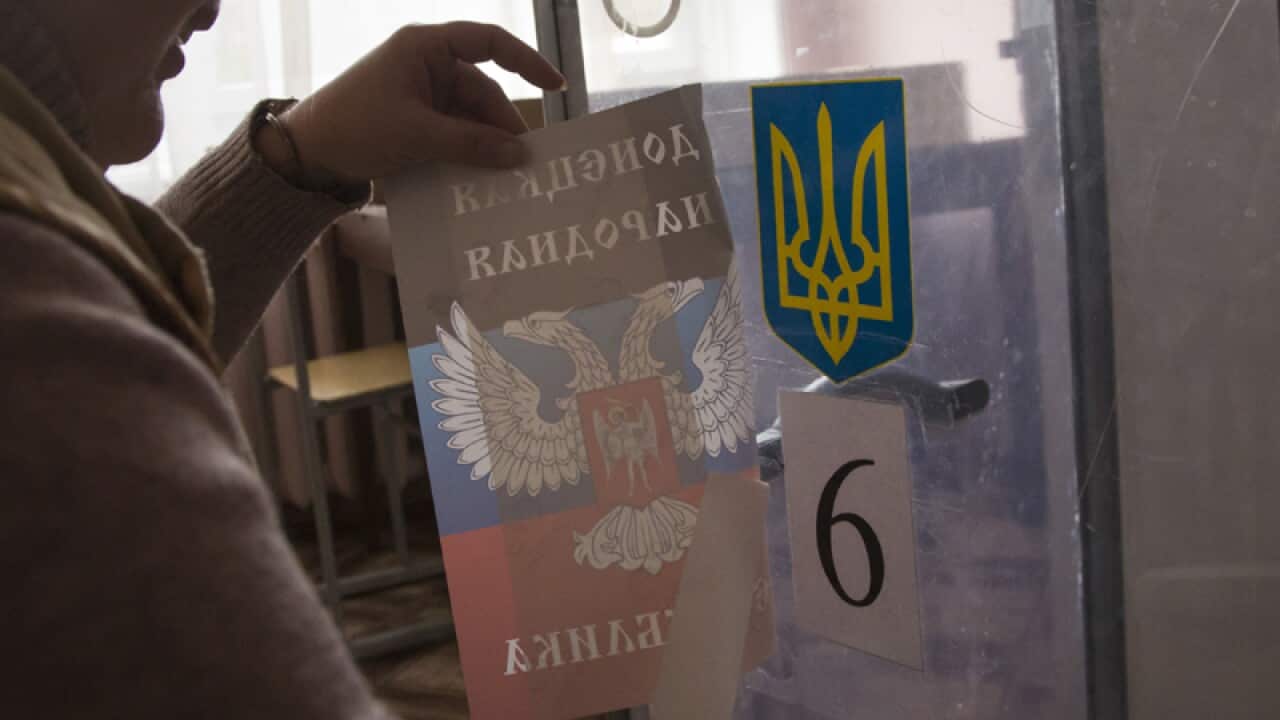A sticker with the rebel symbol is over the Ukrainian national emblem