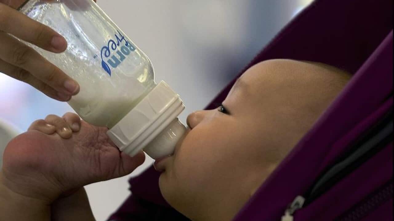 A baby is fed milk from a bottle in Beijing, China