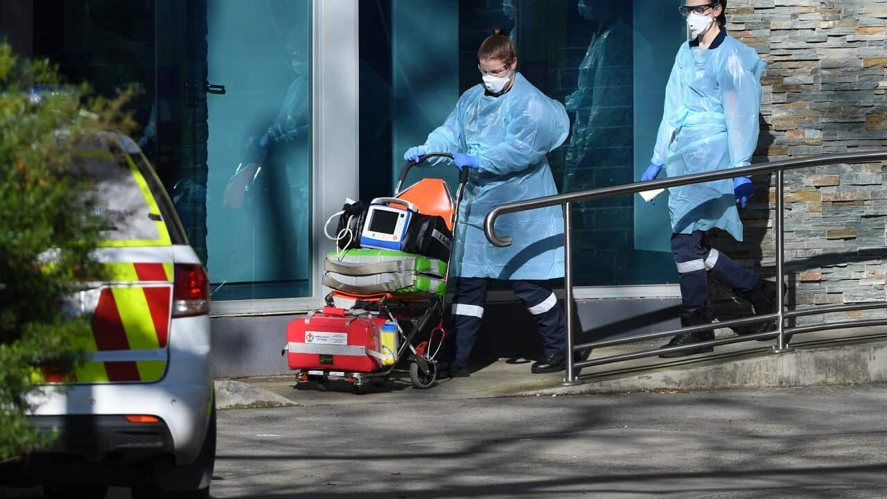 Healthcare workers leave a public housing tower in North Melbourne, Wednesday, July 8, 2020. Nine towers in Flemington and North Melbourne were locked down on Saturday in an effort to slow the spread of coronavirus. (AAP Image/James Ross) NO ARCHIVING