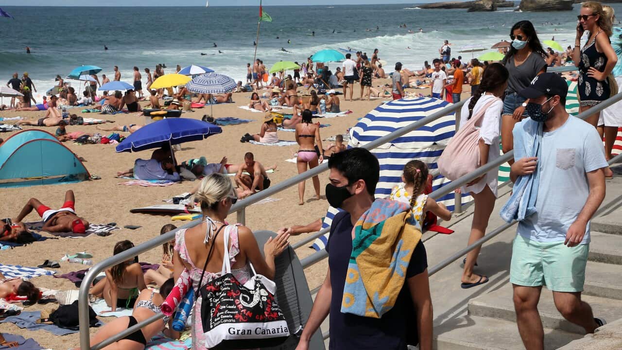 People wearing face masks at the beach in Biarritz, southwestern France.