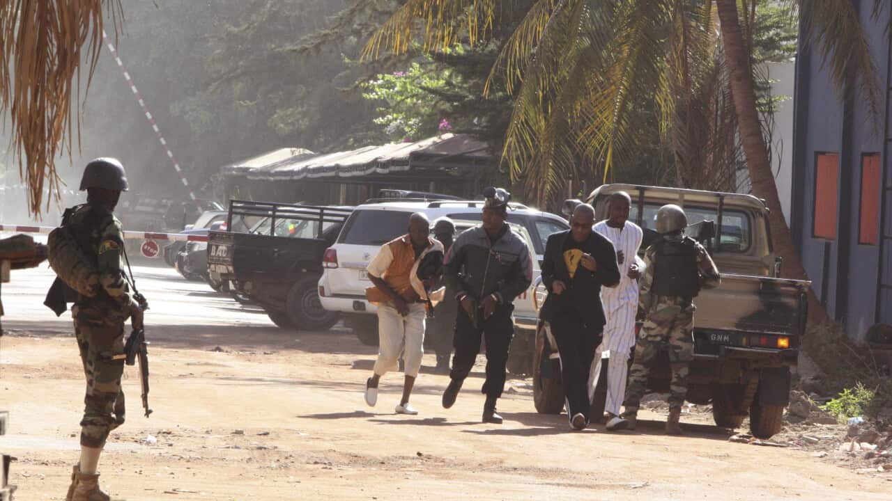 People run to flee from the Radisson Blu Hotel in Bamako, Mali, Friday, Nov. 20, 2015. The company that runs the Radisson Blu Hotel in Mali's capital says assailants have takenhostages in a brazen assault involving grenades. (AP Photo/Harouna Traore)