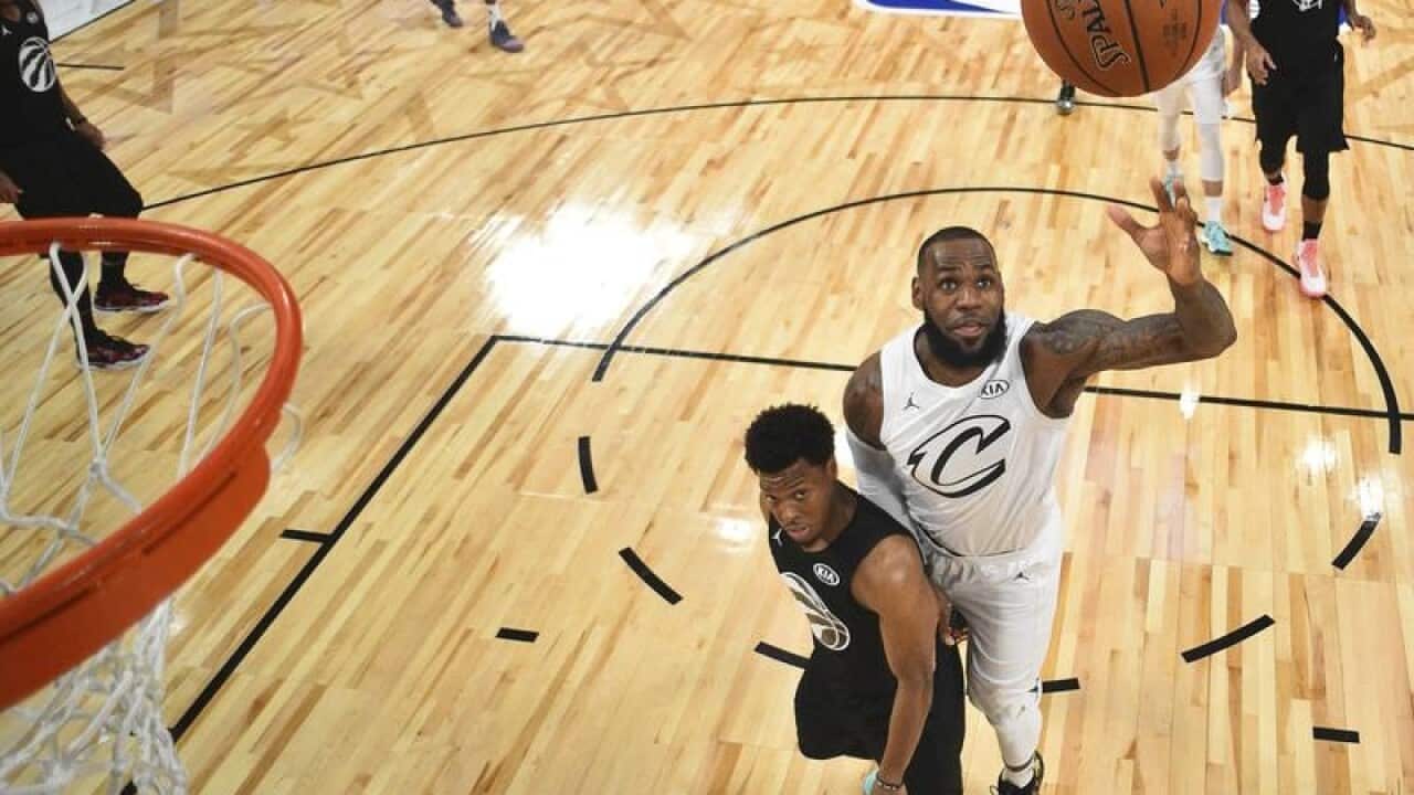 Team LeBron's LeBron James jumps up to the net.
