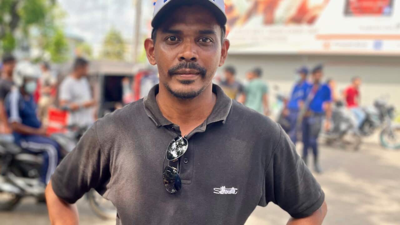 Brian Jason stands in front of a queue in Colombo. He spent six days away from his wife and child waiting for fuel