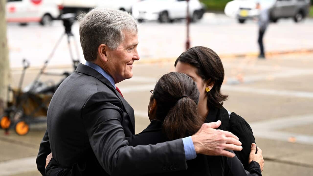 Steve Johnson, the brother of Scott Johnson, embraces his wife Rosemary outside the NSW Supreme Court