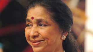 An Indian woman smiles as she looks sideways.