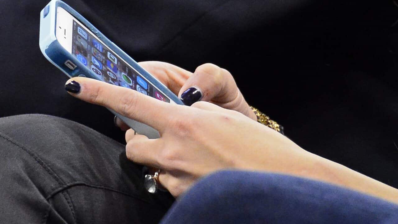 Sexting ... Woman's hands with black fingernails using iPhone.