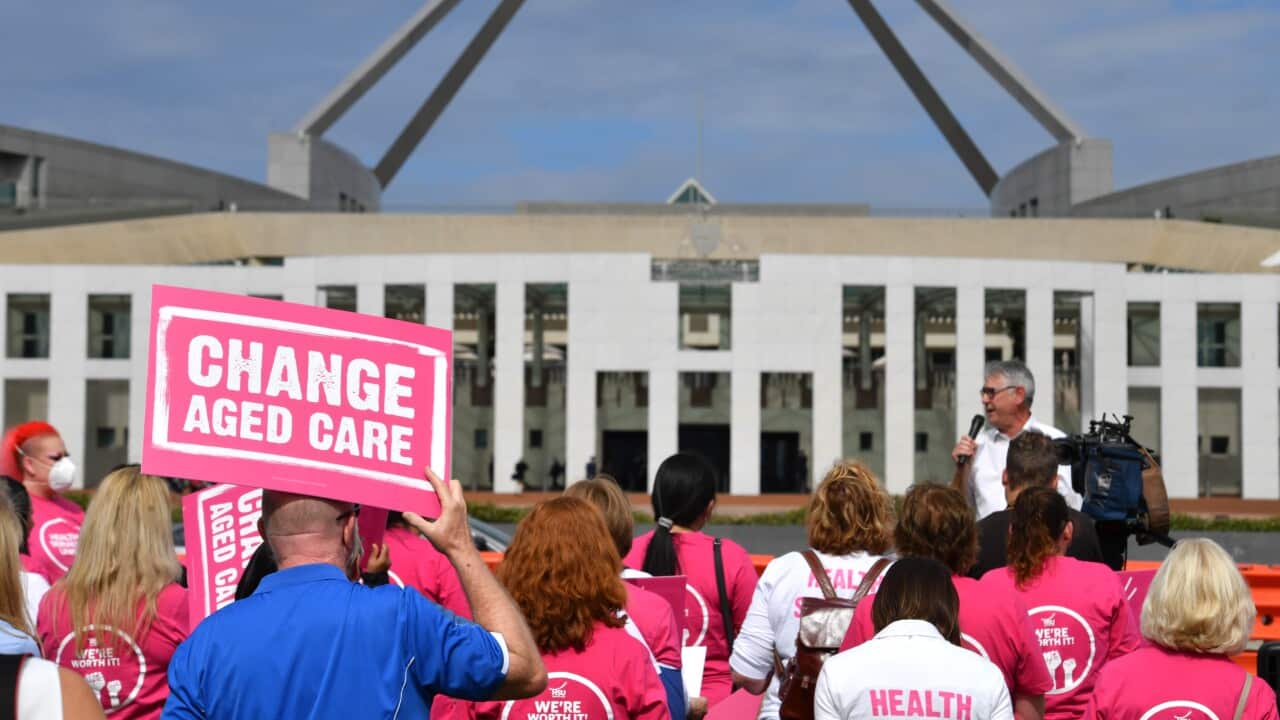Rear view of people standing outside Parliament House in Canberra.