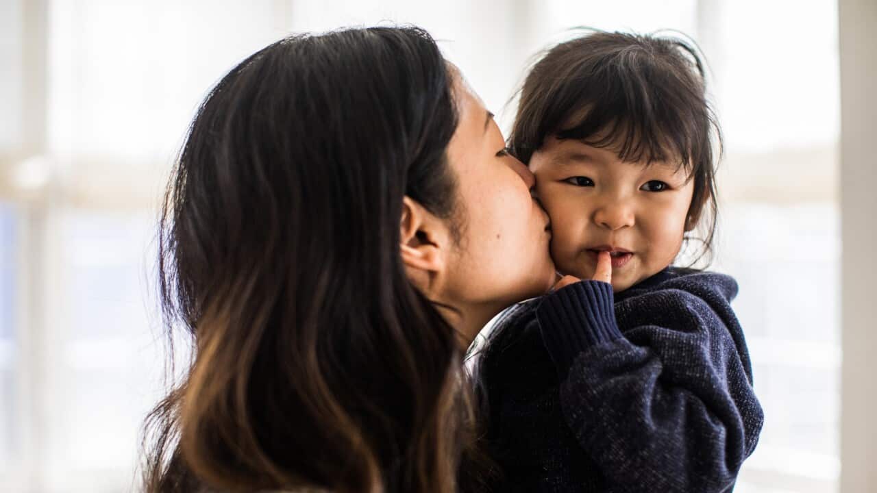 Mother kissing daughter (2yrs) on cheek