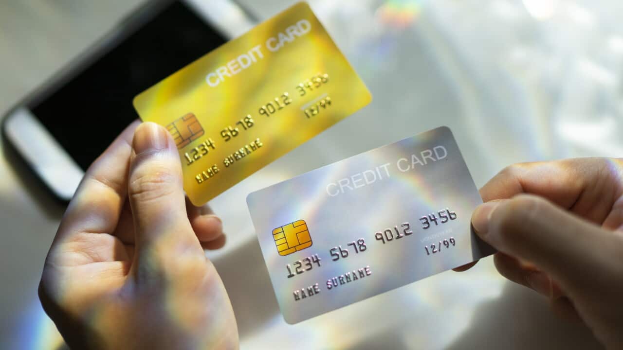 Close up Hand holding Blank credit card black,gold,platinum color with spectrum light and shadow background