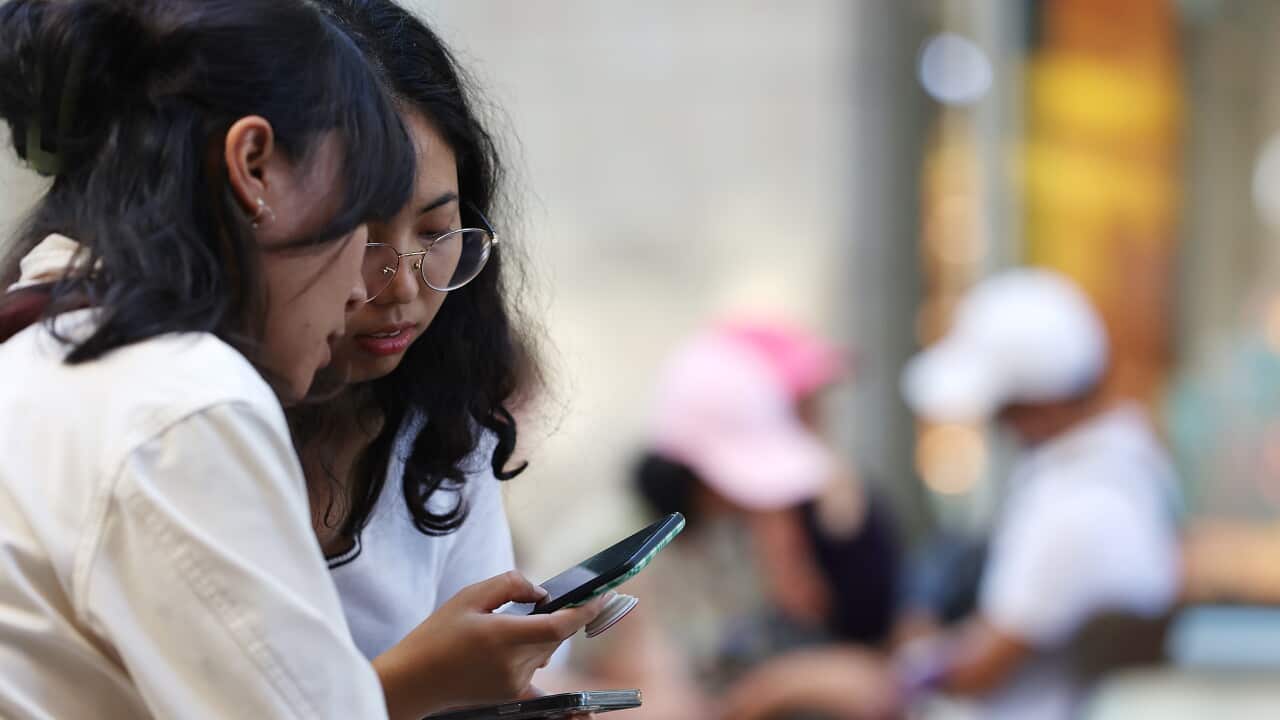 Two teenagers on their smartphones.