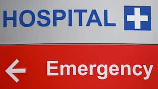 A hospital sign pointing the way to the emergency room. The word hospital appears at the top of the sign in white and blue. Below that, the word Emergency appears in red and white, with an arrow pointing the viewer to the left.