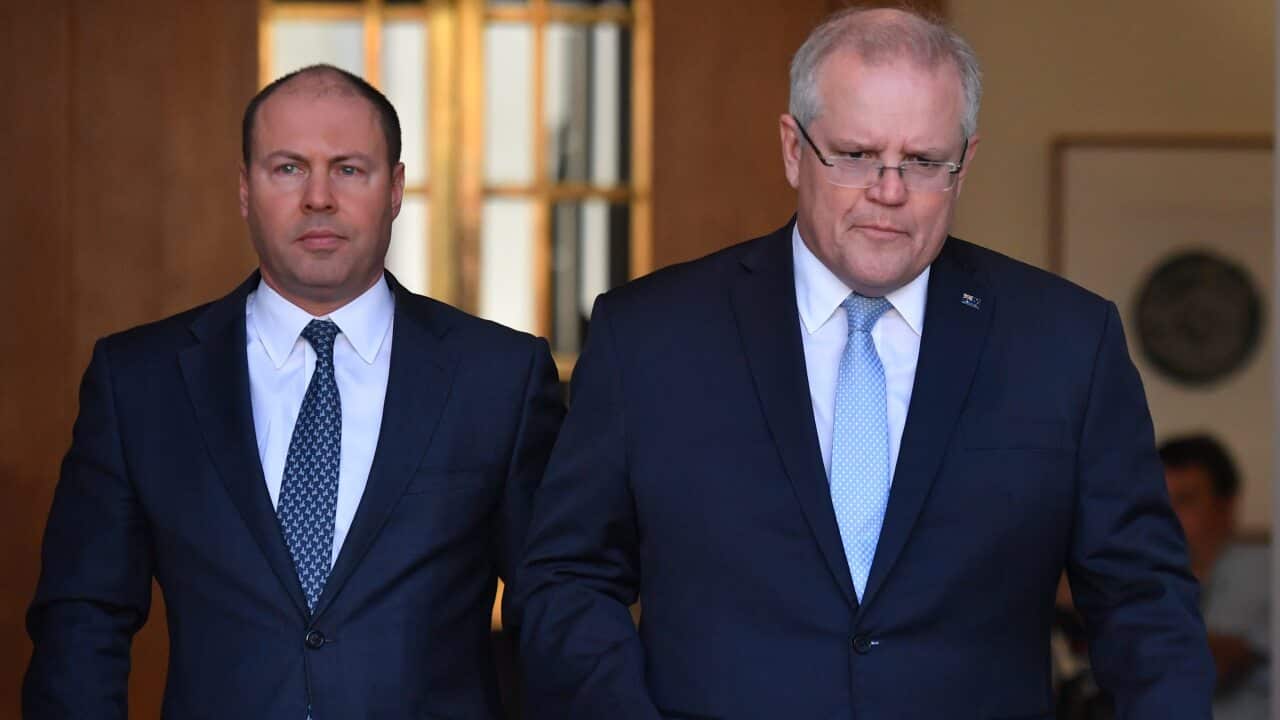 Treasurer Josh Frydenberg and Prime Minister Scott Morrison arrive at a press conference to announce the government's coronavirus stimulus package at Parliament House in Canberra, Sunday, March 22, 2020. (AAP Image/Mick Tsikas) NO ARCHIVING