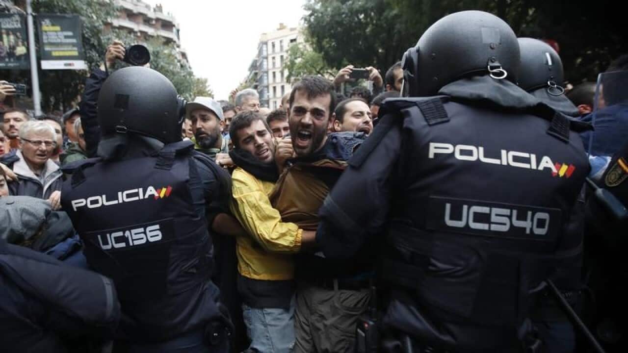 Riot police push back voters in Catalonia.