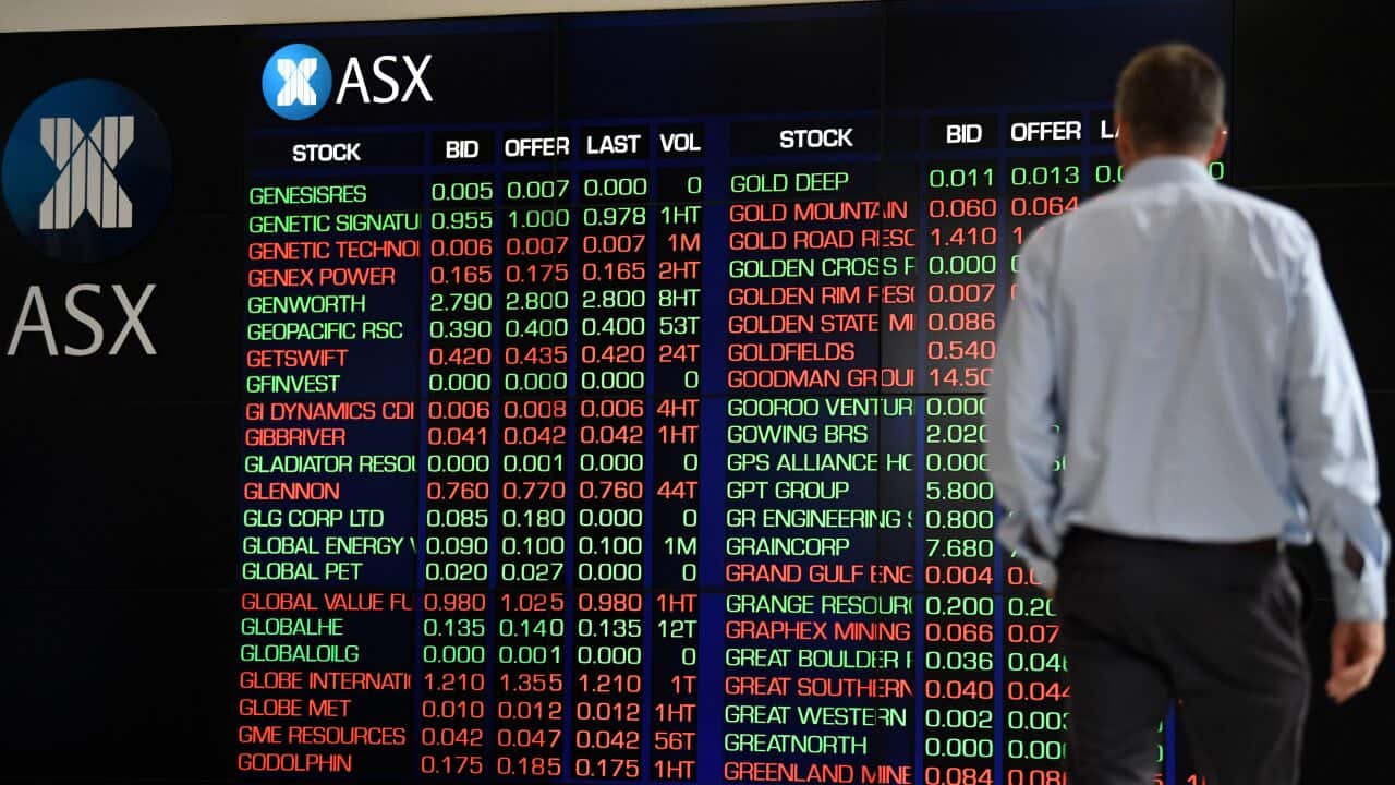 A man observes the digital market boards at the Australian Stock Exchange (ASX).