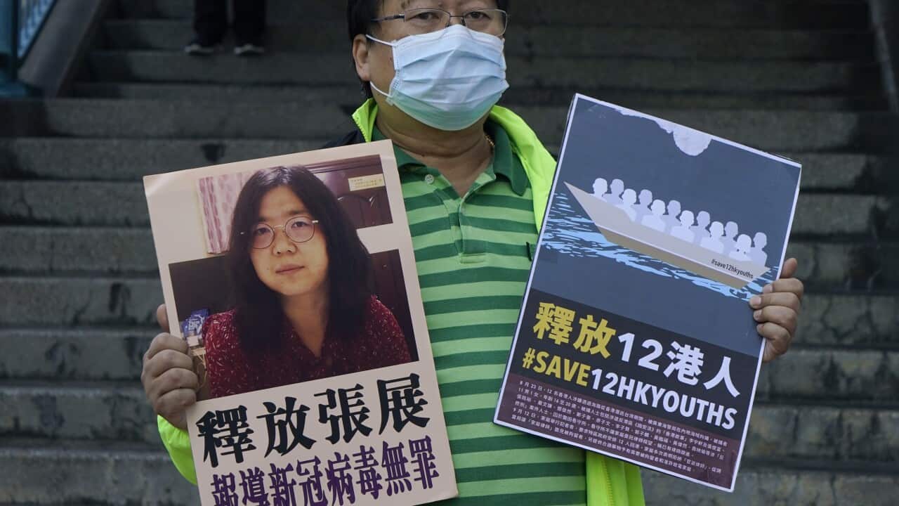 Activist holds placards with picture of Zhang Zhan outside the Chinese central government's liaison office in Hong Kong.