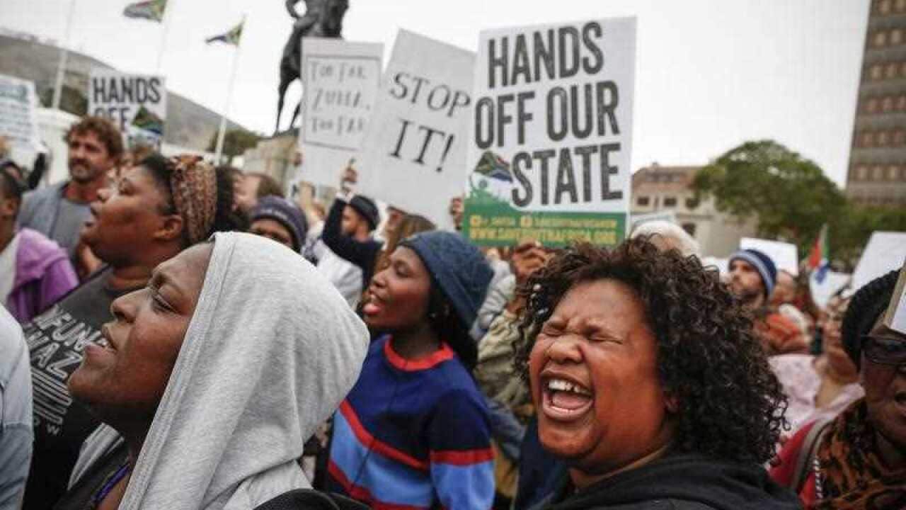 South Africans protest against President Jacob Zuma's cabinet reshuffle outside parliament in Cape Town, South Africa