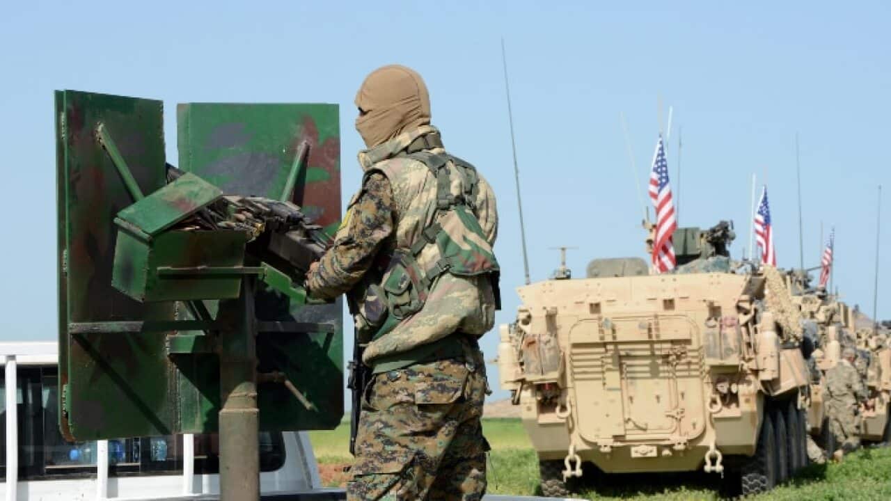 A convoy of US army troops (R) and the People's Protection Units (YPG) Kurdish militia (L) patrol near al-Ghanamya village, al-Darbasiyah town at the Syrian-Turkish border, Syria