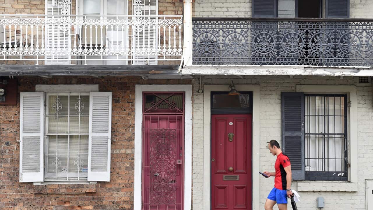 A man walks past some residential houses.