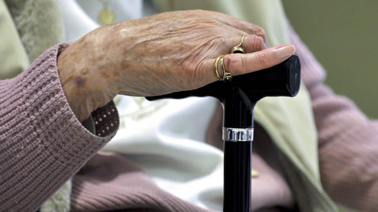 A woman uses a walking stick