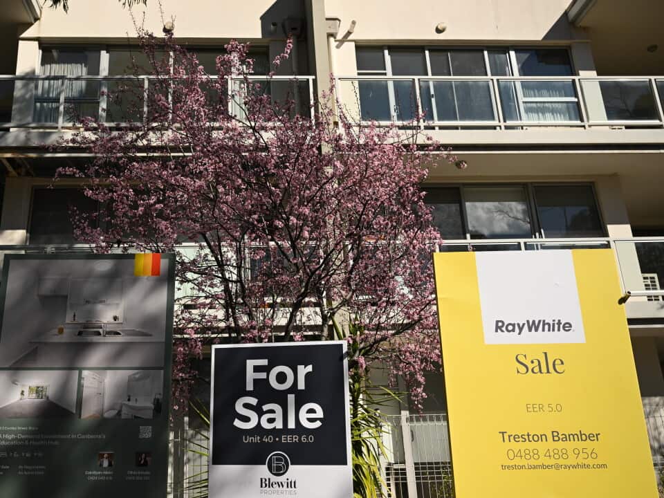 Multiple sale signs outside an apartment block in Canberra - AAP/Lukas Coch