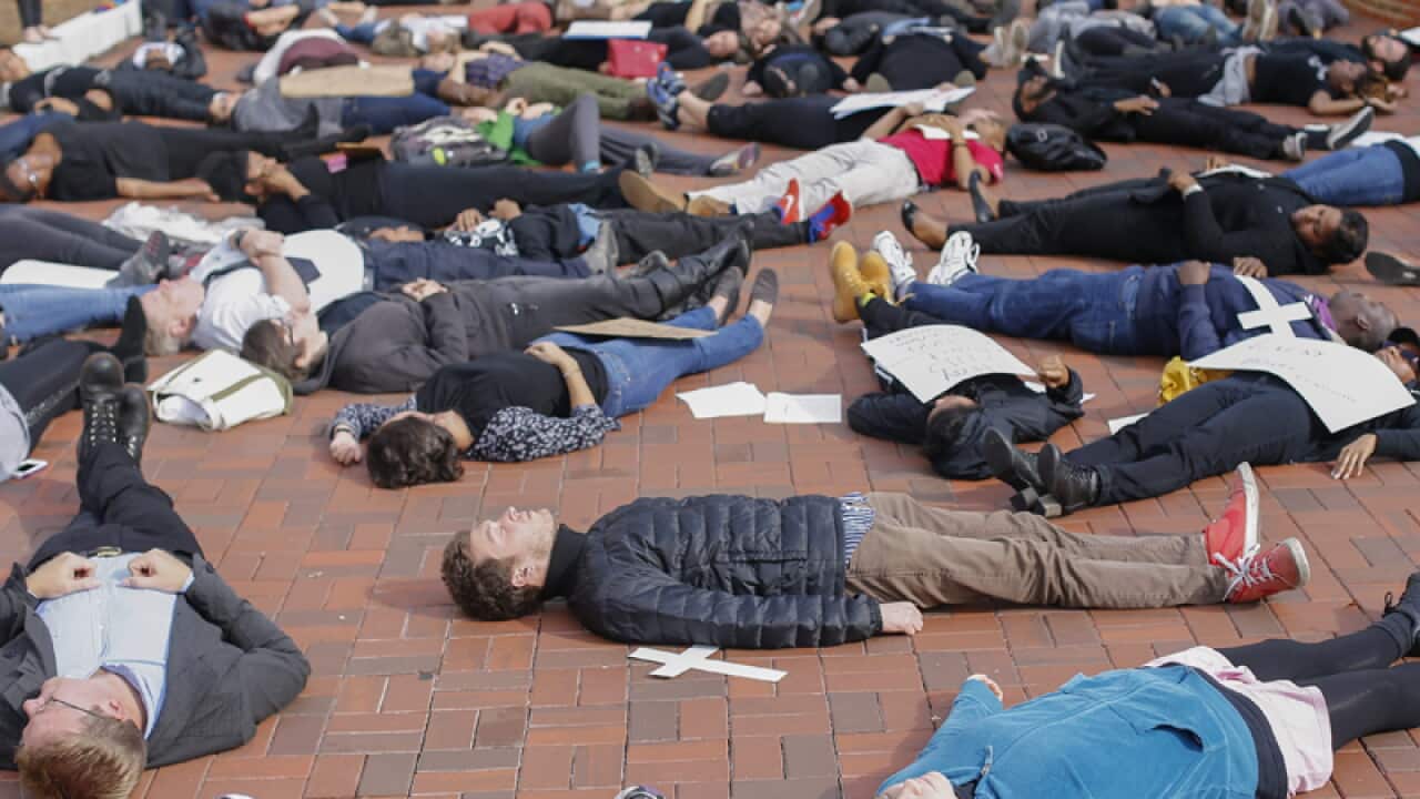 Uni students participate in a mass 'die in' during a protest.