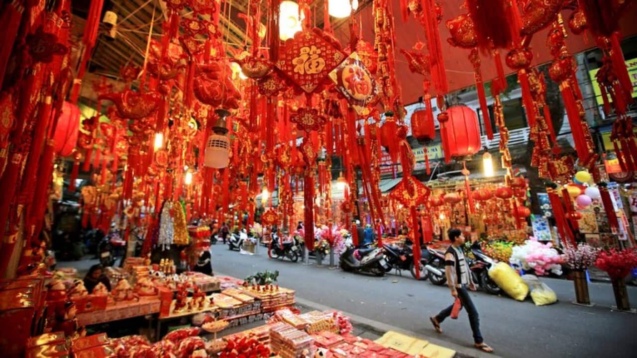 A man walks past a shop selling decorations at a street in Hanoi, Vietnam