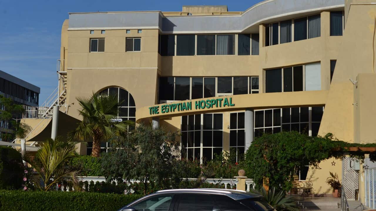 View of a hospital building with trees and cars