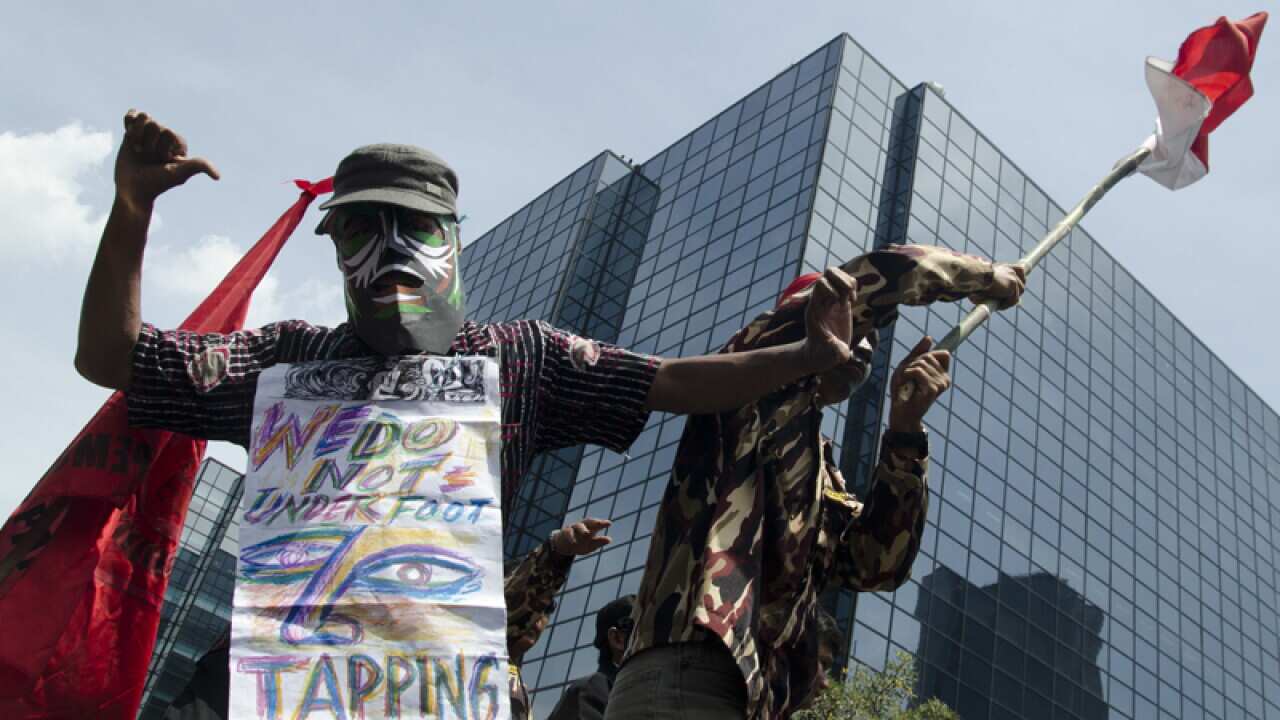 Protesters shout "Taping Is Crime" during a rally