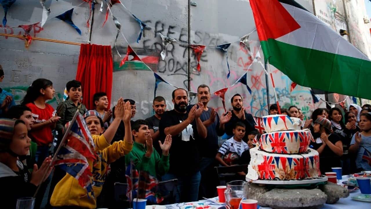 Palestinian children from a refugee camp attend a Banksy art event apologising for the Balfour Declaration in Bethlehem.