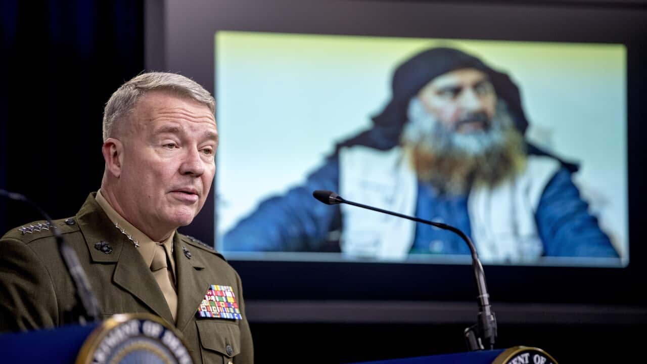 Abu Bakr al-Baghdadi is displayed on a monitor as General McKenzie speaks at a joint press briefing at the Pentagon.