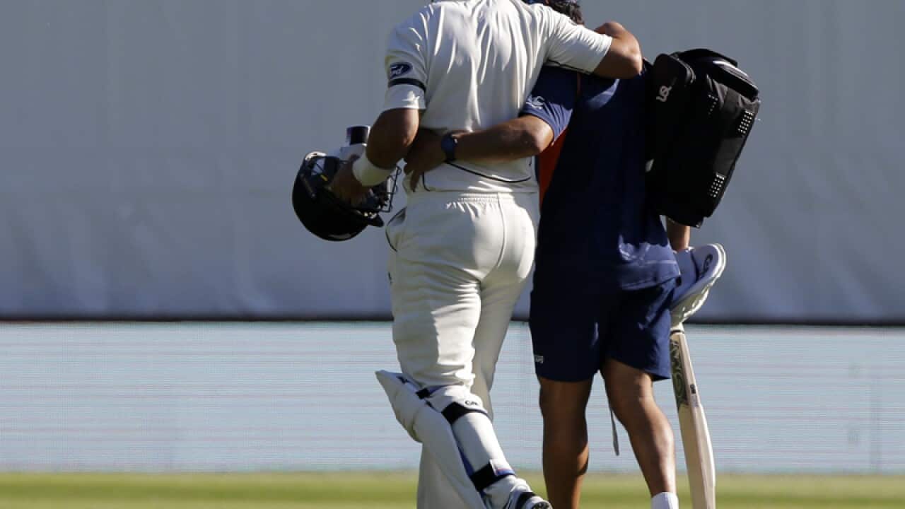 New Zealand batsman Ross Taylor (L) leaves the field injured