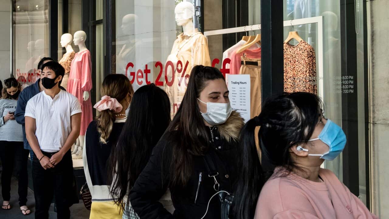 Shoppers in Melbourne wearing face masks as a preventive measure queue at the entrance of H&M for the end of season sale.