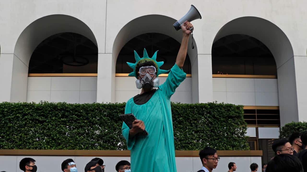 A protester dressed as the Statue of Liberty poses as people march to the US Consulate in Hong Kong
