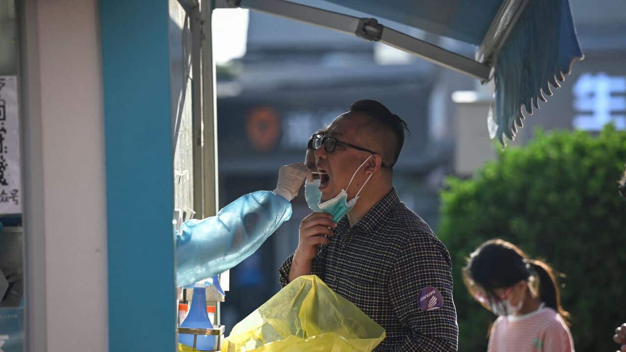 A health worker takes a swab sample from a man to be tested for COVID-19.