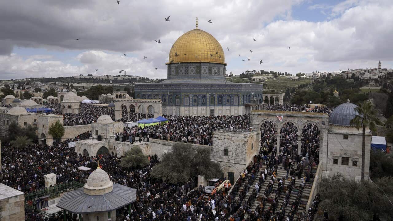 A group of worshippers pray outside the Dome of Rock Mosque at the Al-Aqsa Mosque compound.