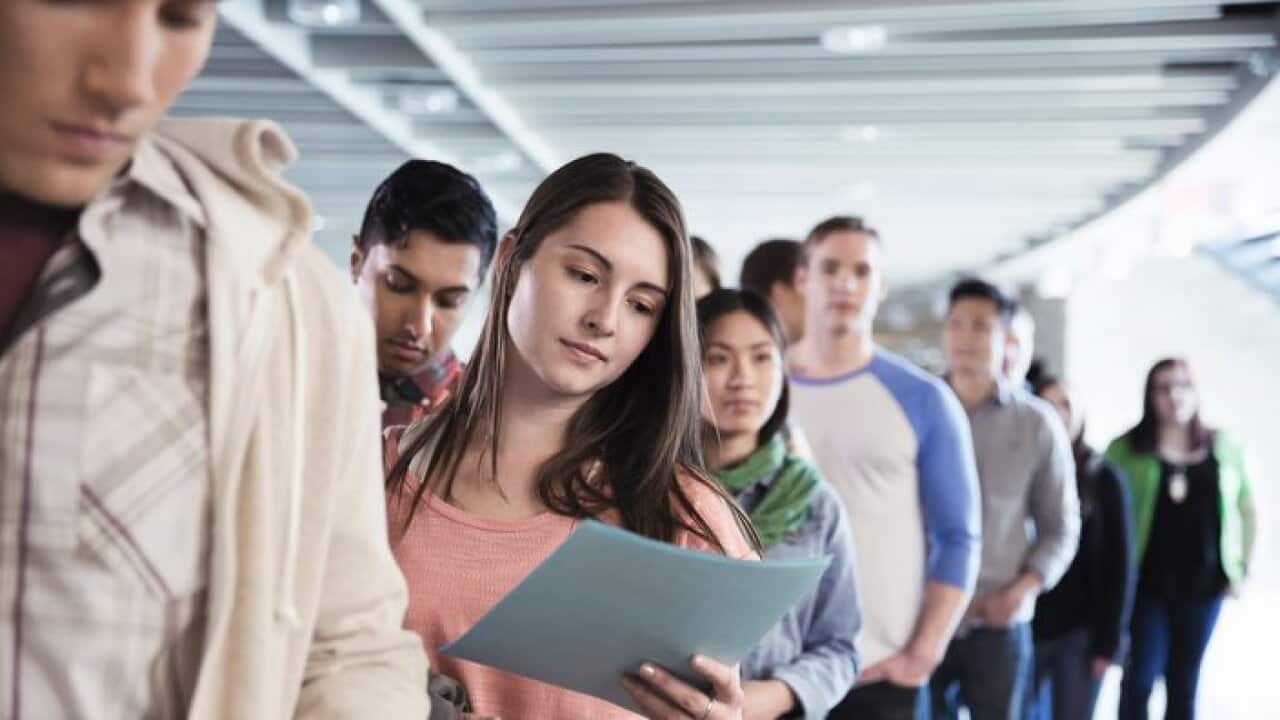 Large group of students standing in line at college campus