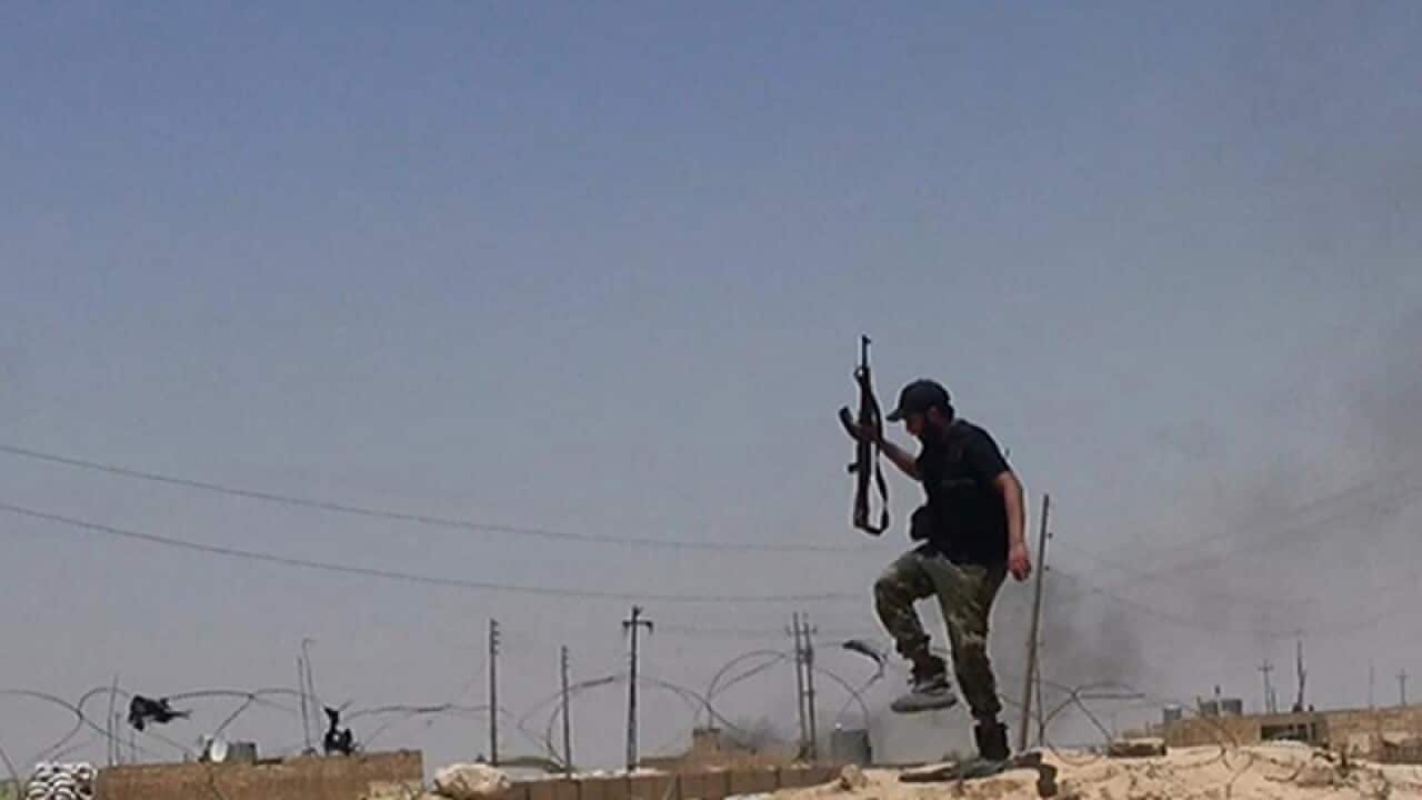 An Iraqi militant holds his weapon at the Syria-Iraqi border