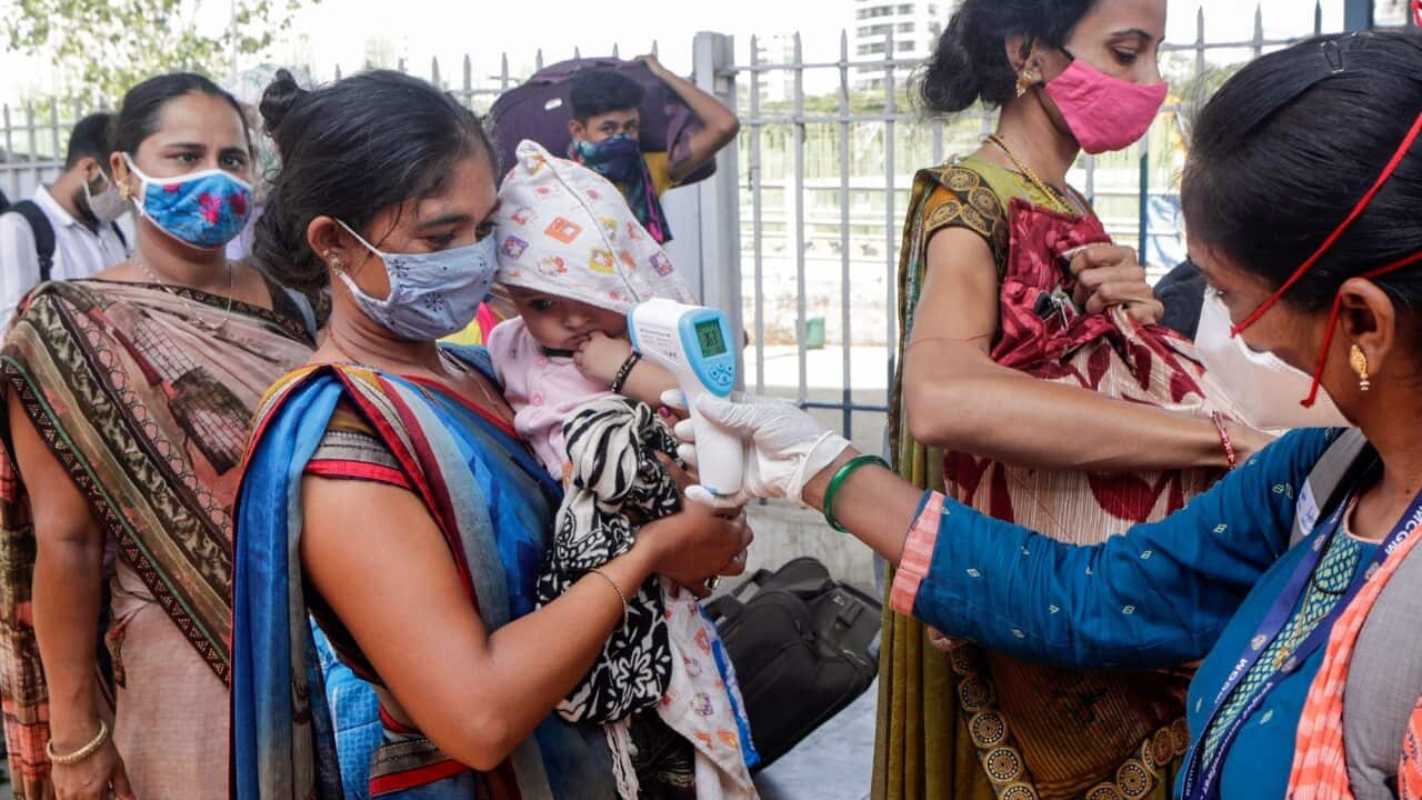 A health worker screens travellers at a train station in Mumbai, India on 24 May 2020.