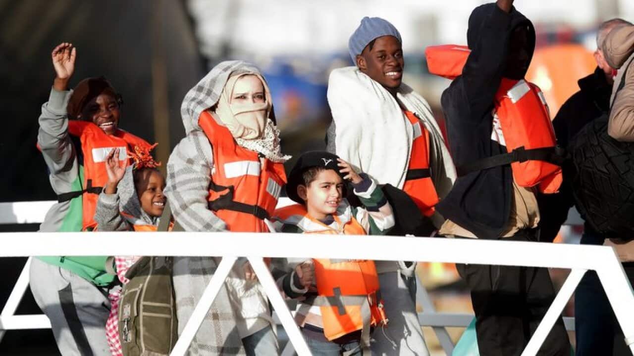 Migrants who had been stranded on two NGO rescue ships off the coast of Malta for several days disembark at the Armed Forces of Malta maritime base.