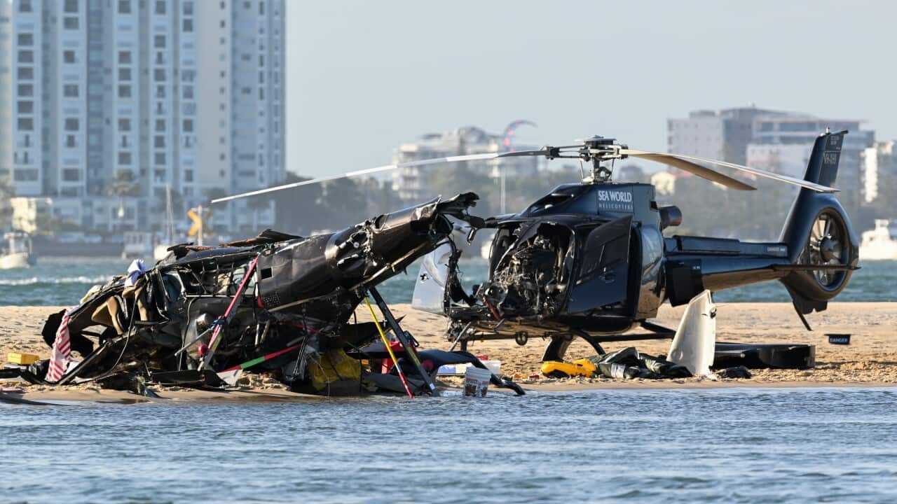 Two damaged helicopters on beach.
