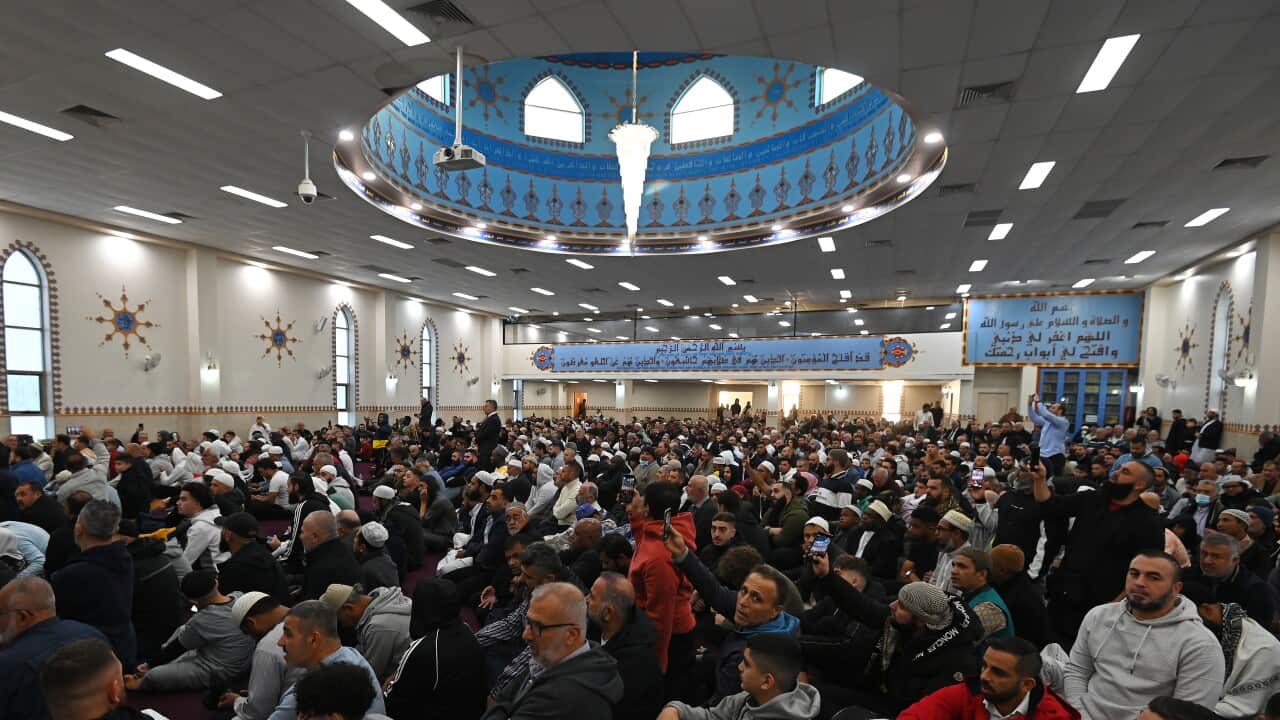 A large group of people inside a large white room