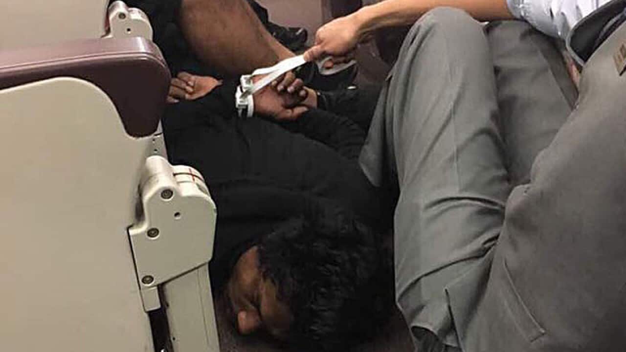 A man is subdued after making bomb threats on a plane